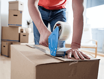Person applying packing tape to moving box